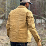 Back view of custom-made sand canvas chore jacket with metal buttons.