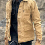 Close up view of custom-made sand canvas chore jacket with metal buttons.